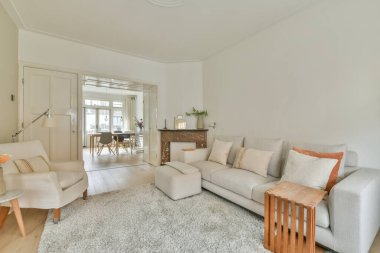 Sandalyeli masa ve rahat kanepe modern dairede şık dekorasyonlarla dolu geniş bir odada.