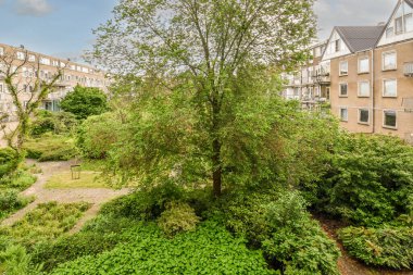 Panoramic view of brick buildings with parking and trees from small balcony