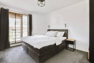 Yatak odasının iç tasarımı, yatak odası ve ahşap gardırop modern dairenin penceresinin kenarına yerleştirilmiş.