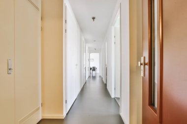 Dar, boş koridor lambalarla aydınlatılmış, minimal tarzda modern dairenin içi