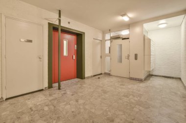 Dar, boş koridor lambalarla aydınlatılmış, minimal tarzda modern dairenin içi