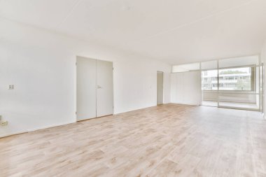 Evdeki boş ışık odasında, beyaz duvardaki plastik pencere ve radyatör.