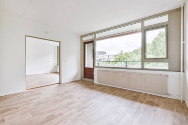 Evdeki boş ışık odasında, beyaz duvardaki plastik pencere ve radyatör.