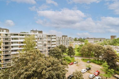 Arabaları, ağaçları ve fenerleri olan boş bir kaldırımdan panorama manzaralı evler.