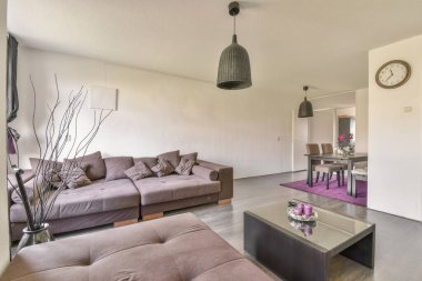 Modern apartmandaki dekorasyonlu ve televizyonlu, rahat koltuğun yanına yerleştirilmiş eski püskü ahşap masa.
