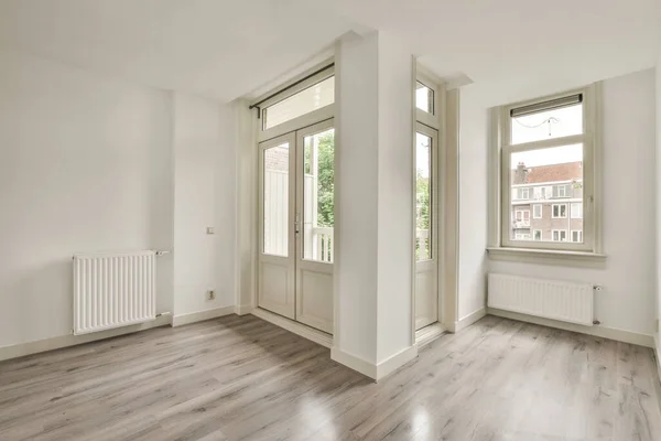 Interior of empty white kitchen with windows and wooden parquet floor