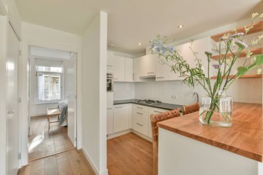 Çağdaş açık mutfak, yemek masası seti ve ferah odada gri kanepe.