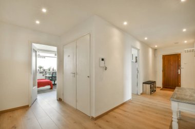 Beyaz duvarları, yumuşak rahat yatağı ve aydınlatmalı minimalist tarzı rafları olan küçük Mansard yatak odasının modern iç tasarımı.