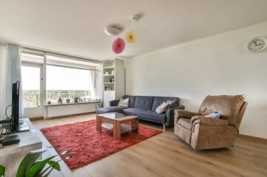 Çağdaş dairenin şık oturma odasındaki kanepe ve televizyonun yanına yerleştirilmiş kare masa.