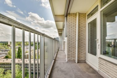 Eski tuğla binaların panoramik manzarası. Küçük balkondan park yerleri ve ağaçlar.