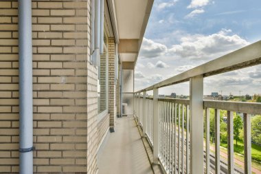 Eski tuğla binaların panoramik manzarası. Küçük balkondan park yerleri ve ağaçlar.