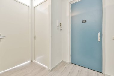 Çağdaş dairenin geniş odasındaki dinlenme odası ve mutfağın yakınındaki sandalyeli ve çiçekli masa.