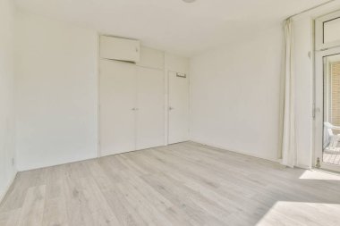 Evdeki boş ışık odasında, beyaz duvardaki plastik pencere ve radyatör.