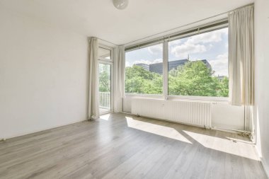 Evdeki boş ışık odasında, beyaz duvardaki plastik pencere ve radyatör.