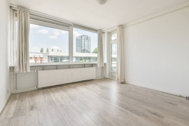 Evdeki boş ışık odasında, beyaz duvardaki plastik pencere ve radyatör.