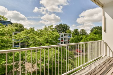 Front view of buildings and cars from small balcony with railings