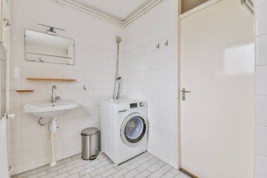 Sinks with mirrors and toilet near shower box with glass door in modern bathroom with white tiled walls