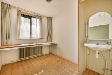 Evdeki boş ışık odasında, beyaz duvardaki plastik pencere ve radyatör.