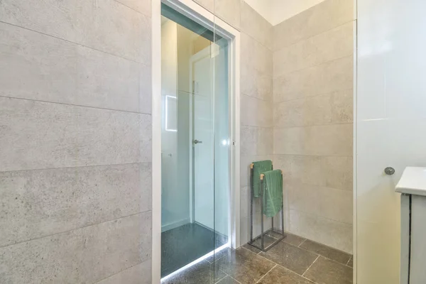 Modern home interior design of white bathroom with open bathtub and shower separated from toilet by partition wall