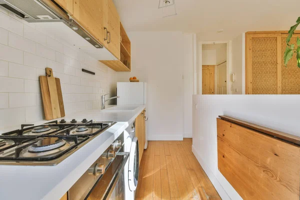 Studio apartment with white walls and open plan kitchen with sofa in living room