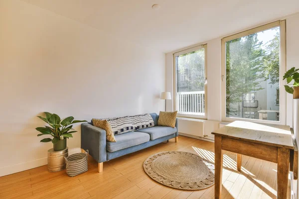 Studio apartment with white walls and open plan kitchen with sofa in living room