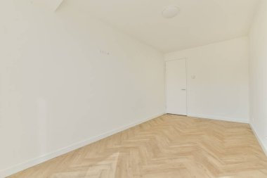 Pencereleri ve ahşap parke zemini olan boş beyaz mutfağın içi.