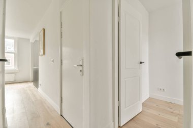 Beyaz duvarları ve aynalı gardırobu ve minimalist tarzda parke zemini olan boş dar koridor manzarası.