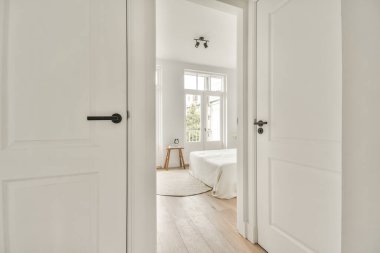 Beyaz duvarları ve aynalı gardırobu ve minimalist tarzda parke zemini olan boş dar koridor manzarası.