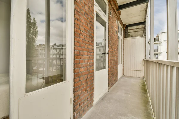 Front view of buildings and cars with bicycles from small balcony with railings