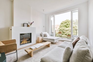 Yumuşak yastıklı rahat bir kanepe şık bir avizenin altında kemerli, ferah bir oturma odasında.