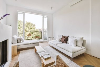 Yumuşak yastıklı rahat bir kanepe şık bir avizenin altında kemerli, ferah bir oturma odasında.