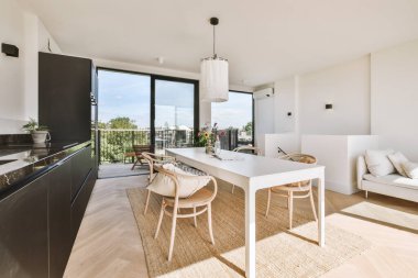 Minimalist tarzı açık mutfağı ve masa ve sandalyeleri olan geniş yemek alanı olan modern çatı katı dairesinin ev tasarımı.