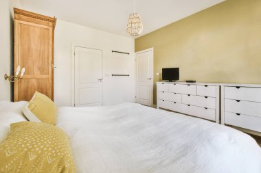 Yatak odasının iç tasarımı, yatak odası ve ahşap gardırop modern dairenin penceresinin kenarına yerleştirilmiş.