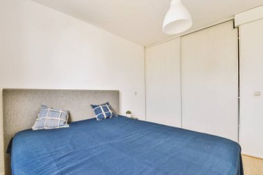 Yatak odasının iç tasarımı, yatak odası ve ahşap gardırop modern dairenin penceresinin kenarına yerleştirilmiş.