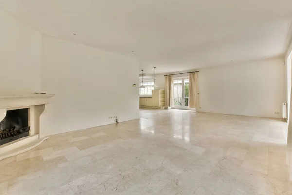 Interior of spacious light room with fireplace against door and windows