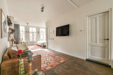 TV 'nin yanındaki koltuklar ve masa, çağdaş apartmandaki geniş odalı yemek alanına karşıdır.