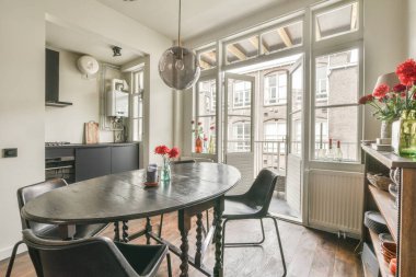 TV 'nin yanındaki koltuklar ve masa, çağdaş apartmandaki geniş odalı yemek alanına karşıdır.