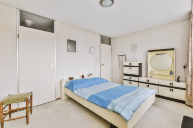 Yatak odasının iç tasarımı, yatak odası ve ahşap gardırop modern dairenin penceresinin kenarına yerleştirilmiş.