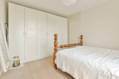 Yatak odasının iç tasarımı, yatak odası ve ahşap gardırop modern dairenin penceresinin kenarına yerleştirilmiş.