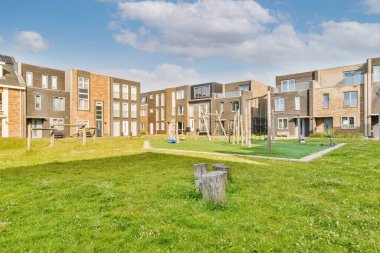 Arabaları, ağaçları ve fenerleri olan boş bir kaldırımdan panorama manzaralı evler.