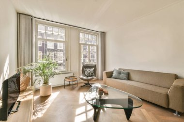 Çağdaş açık mutfak, yemek masası seti ve ferah odada gri kanepe.