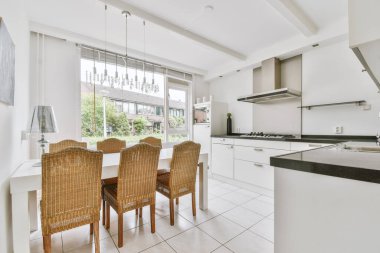 Minimalist tarzı açık mutfağı ve masa ve sandalyeleri olan geniş yemek alanı olan modern çatı katı dairesinin ev tasarımı.