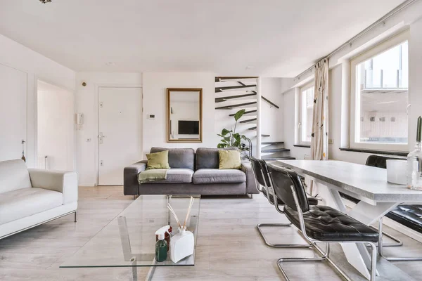 Interior of spacious room with chests of drawers in apartment designed in minimal style