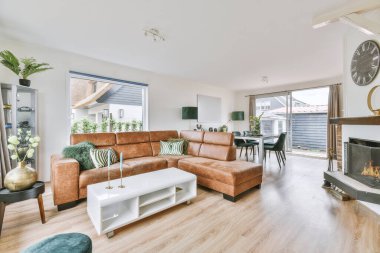 Günümüz minimalist tasarımı. Hafif stüdyo dairesinin ahşap masası ve oturma odası ile beyaz duvarları ve parke zemini arasında yemek masası ve sandalyeleri var.