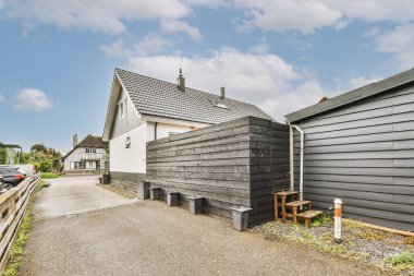 Levhalı, kaldırımlı ve ahşap kapılı bir binanın ön manzarası daireye çıkıyor.