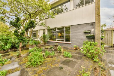 Ahşap çitlerin yanında küçük bahçesi olan basit küçük bir teras.