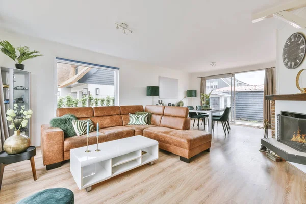 Günümüz minimalist tasarımı. Hafif stüdyo dairesinin ahşap masası ve oturma odası ile beyaz duvarları ve parke zemini arasında yemek masası ve sandalyeleri var.