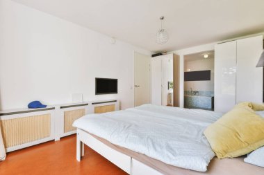 Yatak odasının iç tasarımı, yatak odası ve ahşap gardırop modern dairenin penceresinin kenarına yerleştirilmiş.