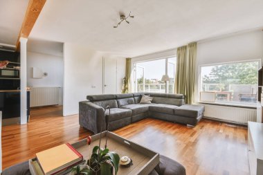 Günümüz minimalist tasarımı. Hafif stüdyo dairesinin ahşap masası ve oturma odası ile beyaz duvarları ve parke zemini arasında yemek masası ve sandalyeleri var.