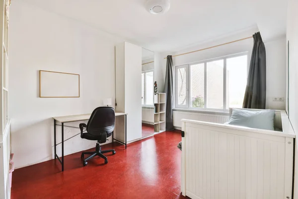 Minimalist interior of study room with parquet floor and white walls furnished with settee and table with shelf rack